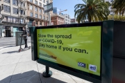 A man rides his scooter by a warning sign in San Francisco, CA, on March 31, 2020. 
Millions of San Francisco Bay Area  residents were ordered to stay home for the third week to slow the spread of the coronavirus as part of a lockdown effort.