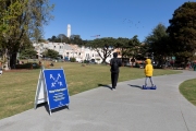 A man and his child in San Francisco on March 31, 2020.  by a sign that asks residents to stay six feet apart to reduce the risk of infection from the coronavirus. 
Millions of San Francisco Bay Area  residents were ordered to stay home for the third week to slow the spread of the coronavirus as part of a lockdown effort.