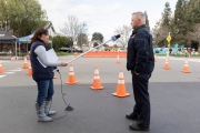 Local KCBS radio reporter Holly Quan uses a long plastic  tube to hold her microphone so she can keep a safe distance from  Hayward Fire Captain Don Nicholson during an interview at the COVID-19 testing center in Hayward, CA, on March 23, 2020.  The free test facility opened to  to the public this morning regardless of where the patients live or their immigration status. The entire state of California is on a shelter-in-place status ordered by the governor to slow the spread of the COVID-19 disease.