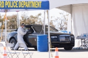 A health care worker tests a woman in a Rolls-Royce car  for COVID-19 at a testing drive-through center in Hayward, CA, on April 15, 2020.  
Hayward firefighters with cooperation with Hayward Police and paramedics set up the center to take pressure off hospital emergency rooms. It is free and available to anyone who show symptoms such as fever.