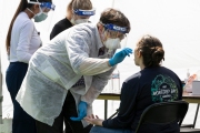 A health worker uses a nasal swab to test a woman at a testing center in the heavily Latino Mission District of San Francisco, CA, on April 25, 2020. Doctors and volunteers set up pop-up testing centers in this district  to test for coronavirus and antibodies all 5,700 residents for free  in one census tract in hopes the data collected will help explain why Latinos and African Americans have been dying at disproportionate rates from COVID-19.