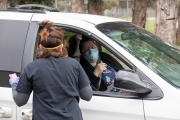 A member of the Hope Ministries Church check-in residents who line up at a drive-through food distribution in South San Francisco, CA, on April 8, 2020.  The food drive was organized to help families in need during the COVID-19 pandemic.