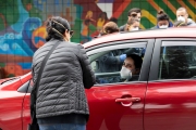 A member of the Hope Ministries Church check-in residents who line up at a drive-through food distribution in South San Francisco, CA, on April 8, 2020.  The food drive was organized to help families in need during the COVID-19 pandemic.