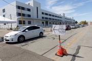 A volunteer checks cars coming into a drive-through food distribution at the Alameda Food Bank distribution center in Alameda, CA, on April 15, 2019, to make sure that they have not already got their weekly share. The food was distributed to people in need following the loss of their jobs due to the “shelter-in-place” order to limit the spread of the coronavirus SARS-CoV-2.