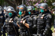 Police officers wearing masks prevent protesters from entering the California State Capitol in Sacramento, CA, on May 1, 2020.