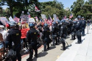 Police officers prevent protesters from entering the California State Capitol in Sacramento, CA, on May 1, 2020.