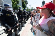 Police officers prevent protesters from entering the California State Capitol in Sacramento, CA, on May 1, 2020.