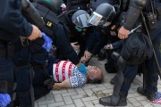 Police officers attend to a protester who fell on the ground in front of the California State Capitol in Sacramento, CA, on May 1, 2020.