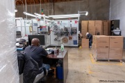 A sighted worker watches his blind colleague filling up up boxes of toilet paper packets at the Sirkin Center in San Leandro, CA, on May 11, 2020.