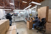 A sighted worker watches his blind colleague filling up up boxes of toilet paper packets at the Sirkin Center in San Leandro, CA, on May 11, 2020.