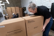 A visually impaired worker moves a box of toilet paper packets that just came out of the production line at the Sirkin Center in San Leandro, CA, on May 11, 2020.