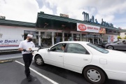 A waiter or carhop brings a meal to a customer waiting in his car at the Mel’s  Drive-In restaurant in San Francisco, CA, on May 12, 2020.Like in the 1950’s, Mel's Drive-In restaurant in San Francisco is now offering carhop service so customers stay safe while still feeling like they get the experience of eating out during the shelter-in-place order due to the coronavirus pandemic.