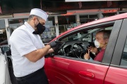 A waiter or carhop takes an order from a customer waiting in his car at the Mel’s  Drive-In restaurant in San Francisco, CA, on May 12, 2020.Like in the 1950’s, Mel's Drive-In restaurant in San Francisco is now offering carhop service so customers stay safe while still feeling like they get the experience of eating out during the shelter-in-place order due to the coronavirus pandemic.