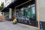 Workers boarding up stores in Oakland, CA, on May 30, 2020, after some were broken into and looted following violent  protests the night before.