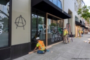 Workers boarding up stores in Oakland, CA, on May 30, 2020, after some were broken into and looted following violent  protests the night before.
