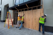 Workers boarding up stores in Oakland, CA, on May 30, 2020, after some were broken into and looted following violent  protests the night before.
