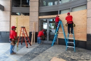 Workers boarding up stores in Oakland, CA, on May 30, 2020, after some were broken into and looted following violent  protests the night before.
