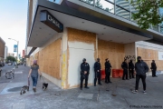 Police officers stand guard in front of Chase bank  in Oakland, CA, on May 30, 2020, that had its storefront boarded up following violent  protests the night before.